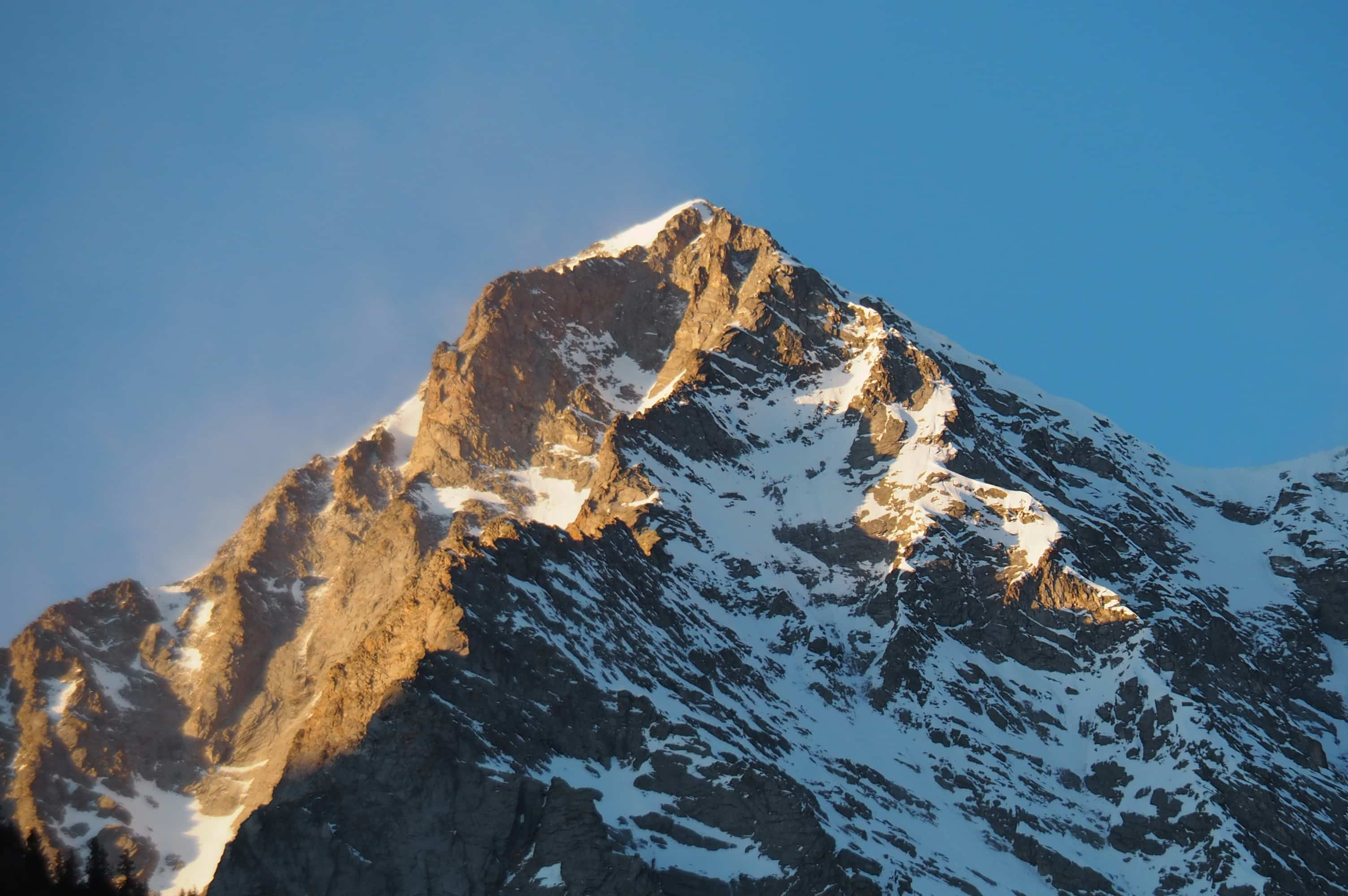 Mountain summit at sunrise with snow